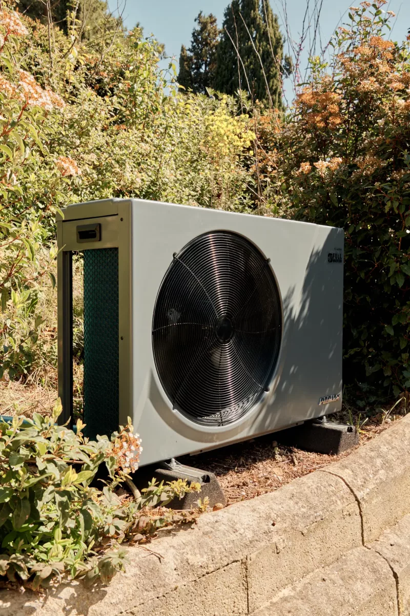 Pompe à chaleur Poolex Silverline installée en extérieur, vue de côté avec grille latérale visible