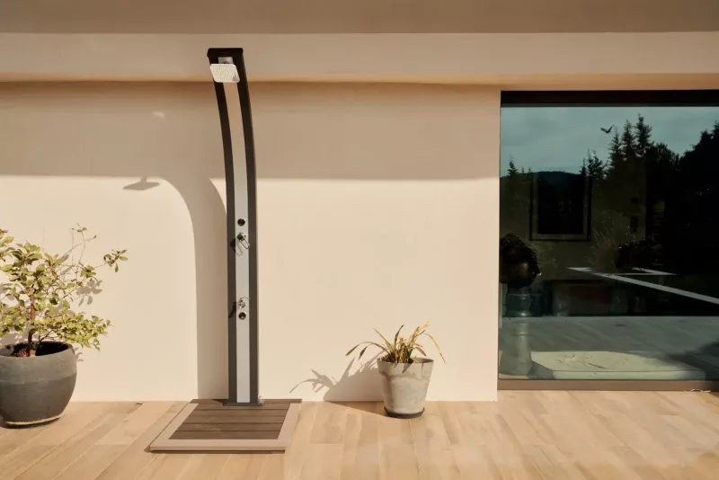 Douche solaire Spring 30L rose – vue de face en situation dans un jardin